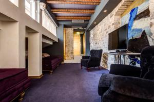 a living room with couches and a tv and a wall at Boutique Hotel Hippocampus in Kotor