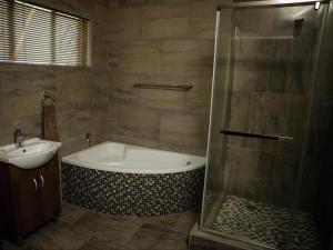 a bathroom with a bath tub and a sink at Goldfields Gardens Guesthouse in Virginia