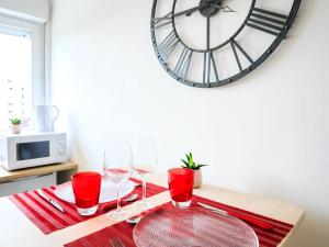 une table avec des verres à vin et une horloge sur le mur dans l'établissement 1er Mai, à Clermont-Ferrand