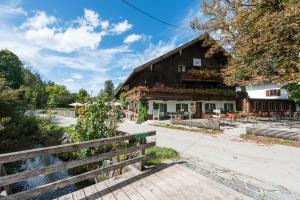 a barn with a wooden fence in front of it at RamsAu-das Gasthaus in Bad Heilbrunn
