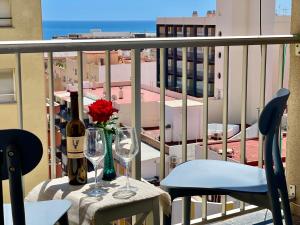 a table with two glasses and a bottle of wine on a balcony at COLIBRI Cómodo, bonito, céntrico in Calpe