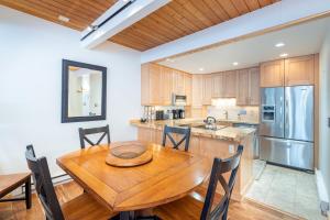 a kitchen with a wooden table and a refrigerator at Riverside A in Telluride