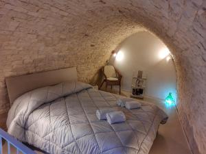 a bedroom with a bed in a stone wall at Mirum Apuliae 16 in Alberobello