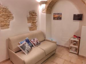 a living room with a couch with pillows on it at Mirum Apuliae 16 in Alberobello