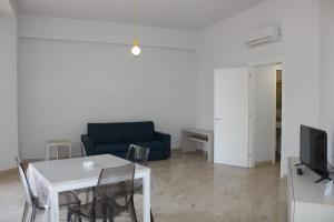 a living room with a white table and a blue couch at Zibibbo Beach Apartments - Trapani in Trapani