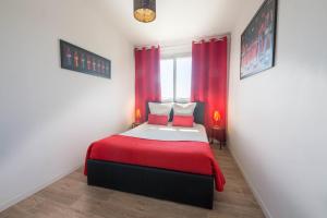 Un dormitorio con una cama con sábanas rojas y una ventana en Coca gare en Clermont-Ferrand