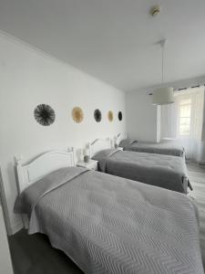 2 Betten in einem Schlafzimmer mit weißen Wänden in der Unterkunft Casa de Hospedes D. Maria Parreirinha in Sintra