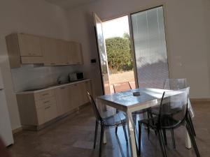 a kitchen with a table and chairs in a room at Zibibbo Beach Apartments - Trapani in Trapani