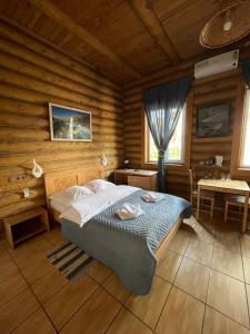 1 dormitorio con 1 cama en una cabaña de madera en Art-eco-hotel Altai, en Bisk