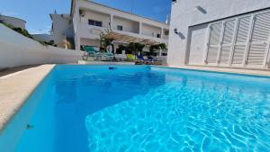 una piscina de agua azul frente a una casa en Villa Gabriel by Sunny Deluxe, en Albufeira