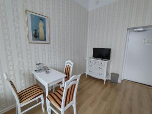 a dining room with a table and chairs and a television at Liahof in Ullared