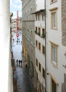 een groep mensen die door een straat lopen tussen twee gebouwen bij Olga's House in Florence