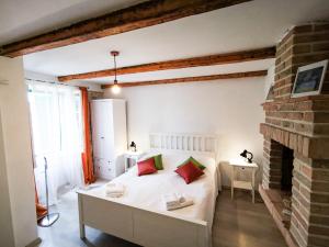 um quarto com uma cama branca com almofadas vermelhas e verdes em Val Comeza em Komiža