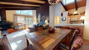 a living room with a wooden table and a kitchen at Chateau De Montagne #23 Condo in Mammoth Lakes