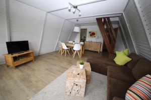 een woonkamer met een bank en een tafel bij Ferienhäuser Campingplatz in Kinding