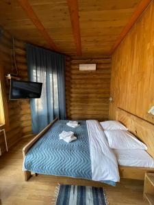 1 dormitorio con 1 cama en una cabaña de madera en Art-eco-hotel Altai, en Bisk