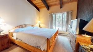 a bedroom with a large bed and a tv at Chateau De Montagne #23 Condo in Mammoth Lakes +30 photos