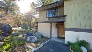 a house with a window and a door and some rocks at Chateau De Montagne #23 Condo in Mammoth Lakes