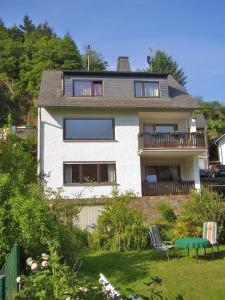 a white house with a balcony and a table at Ferienwohnung Klemm, Burgen /Untermosel in Burgen