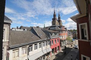 Blick auf eine Stadtstraße mit Gebäuden und einer Kirche in der Unterkunft Appart Nicolas in Eupen