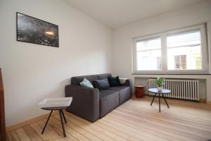 uma sala de estar com um sofá e uma janela em Appart Nicolas em Eupen