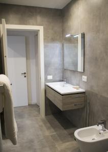 a bathroom with a sink and a toilet and a mirror at Bloom Apartments in Trento