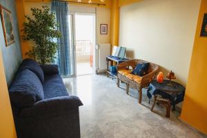 sala de estar con sofá azul y sillas en Sunray luxury apartment Volos, en Volos
