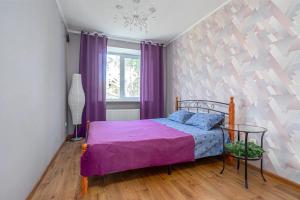 a bedroom with a purple bed and a window at Квартира в центре in Kazan