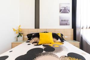 ein Schlafzimmer mit einem Bett mit gelben und schwarzen Kissen in der Unterkunft SYLVIA 1M - Precioso apartamento en primera línea de mar - céntrico - playa - wifi in Empuriabrava