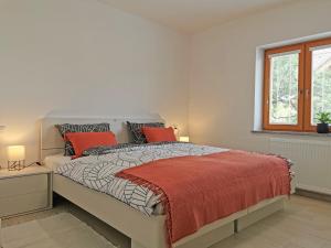 a white bedroom with a large bed with red pillows at Apartment Vida in Bled