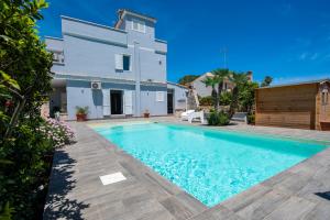 una villa con piscina frente a una casa en Villa Lucilla Charming House - Fontane Bianche, en Fontane Bianche
