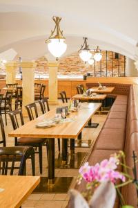 un restaurante con mesas de madera, sillas y luces en Landhotel Sonnenhof en Ossig