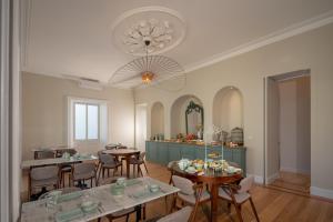 a dining room with tables and chairs and a chandelier at Casa do Pateo - Charming House Azores in Ponta Delgada