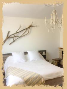 a bedroom with a white bed and a chandelier at La Bulle dans le Palmier in Toulouse