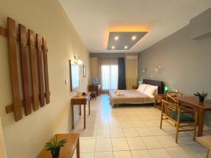 um quarto de hotel com uma cama, uma mesa e cadeiras em Thrassa Hotel em Tycherón