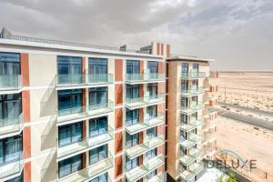 an apartment building with the beach in the background at Calm Studio in Damac Celestia A Dubai South by Deluxe Holiday Homes in Dubai