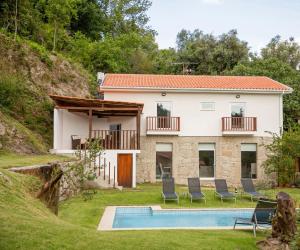 a villa with a swimming pool and a house at Casa da Pontelha in Terras de Bouro