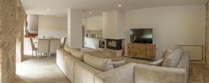 a living room with a large couch and a television at Casa da Pontelha by Gerês Casas in Terras de Bouro