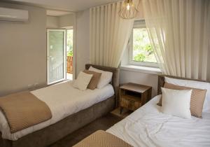 two beds in a room with two windows at Casa da Pontelha by Gerês Casas in Terras de Bouro +36 photos