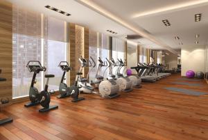 a gym with a row of treadmills and ellipticals at Calm Studio in Damac Celestia A Dubai South by Deluxe Holiday Homes in Dubai