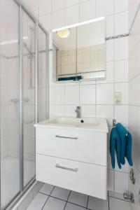 ベンサージールにあるFerienwohnung Deichblickの洗面台とシャワー付きの白いバスルーム