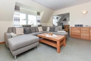 a living room with a couch and a coffee table at Ferienwohnung Deichblick in Bensersiel
