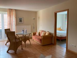 ein Wohnzimmer mit einem Tisch, einem Sofa und einem Bett in der Unterkunft Hotel Die Friesenhalle in Bredstedt