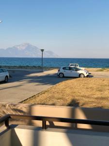 two cars parked on a road next to the ocean at Villa Lemar in Sarti
