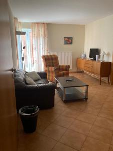 a living room with a couch and a coffee table at Hotel Die Friesenhalle in Bredstedt