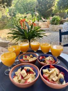 una mesa con tazones de comida y vasos de zumo de naranja en Asis de Marratxinet, en Marratxí 