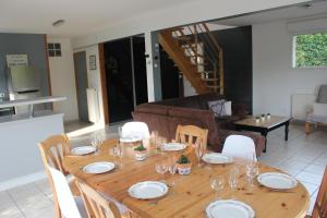 een houten tafel met borden en wijnglazen erop bij Gites Le John Jeffries - Le Grand Jeff in Guînes