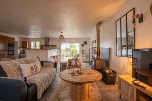 a living room with a couch and a table at Maison 10 personnes - Jardin - Noirmoutier-en-l Ile in Noirmoutier-en-l'lle