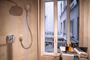 a shower in a bathroom with a sink and a window at 136 - Urban Beaumarchais Voltaire in Paris