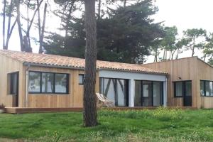 una casa con un árbol delante de ella en Villa Ile de Re avec acces mer du jardin, en Rivedoux-Plage